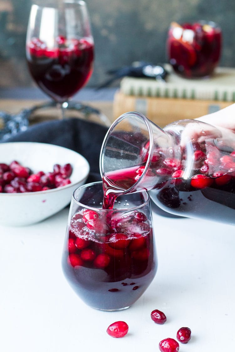 Pouring sangria into a wine glass.