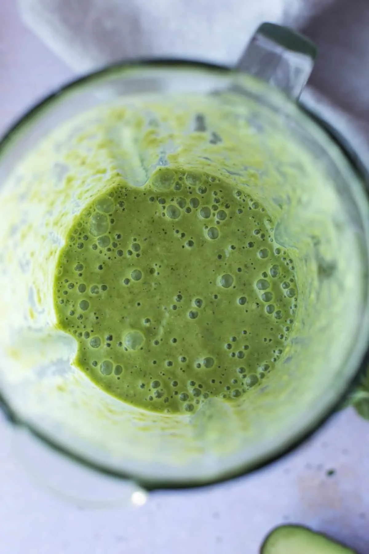 Blender with blended green smoothie, seen from the top.