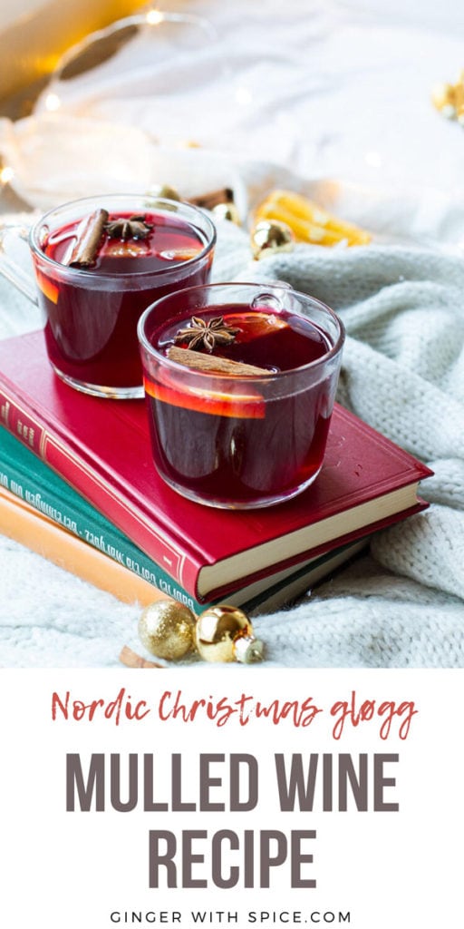 Glass mugs with mulled wine on a red book. Pinterest pin with text.