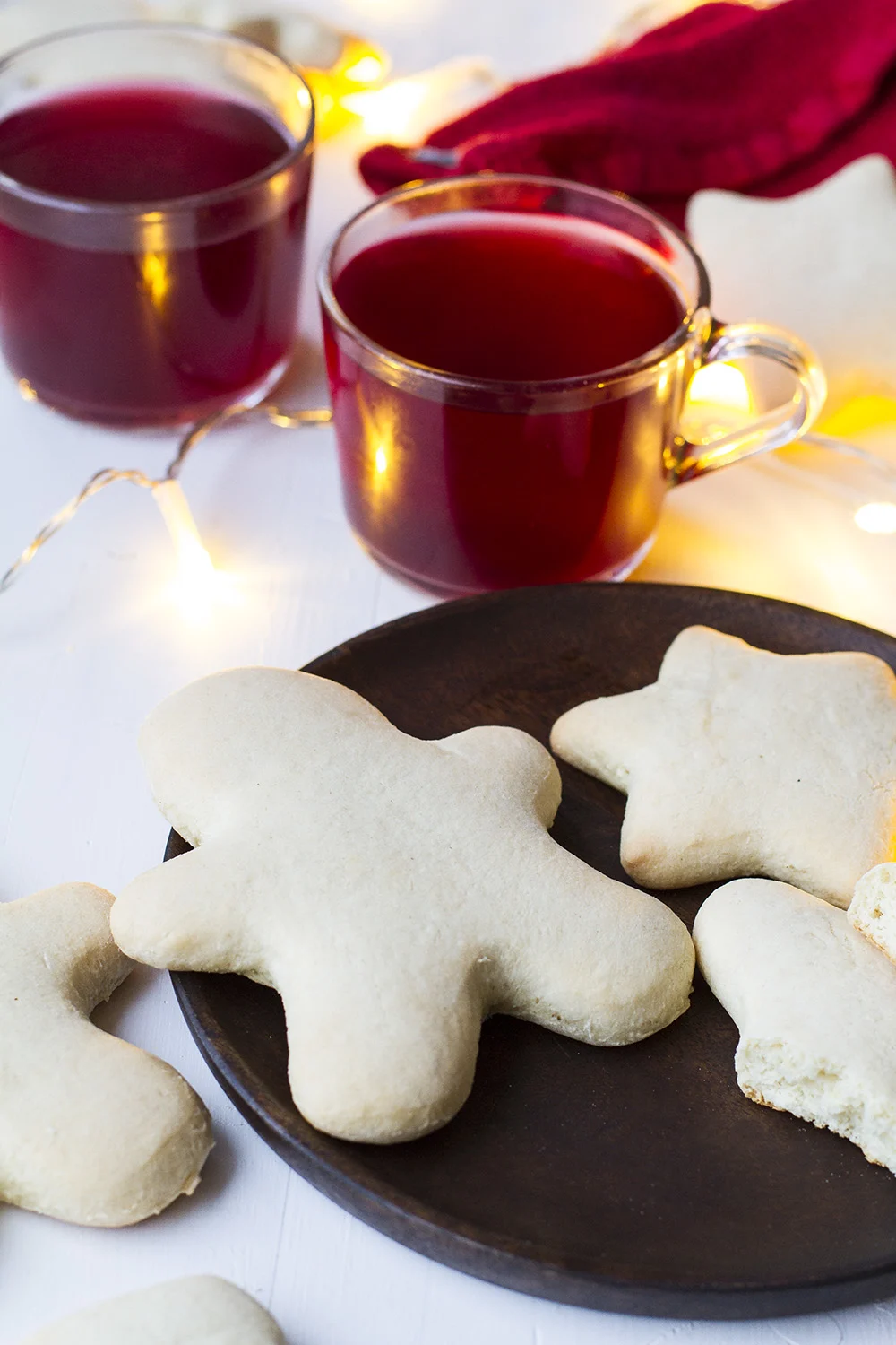 A wooden plate with Norwegian Christmas cookies, mulled wine in the background.