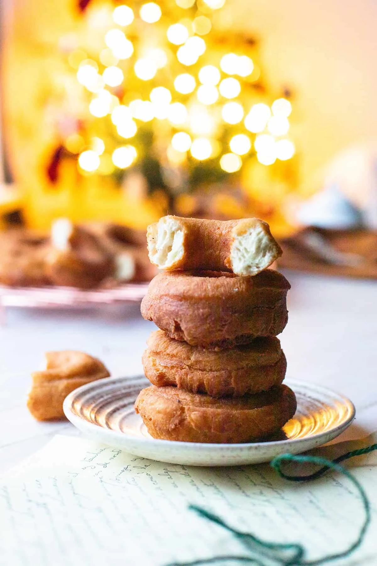 A stack of three donuts and one halved at the top to show the fluffy insides.