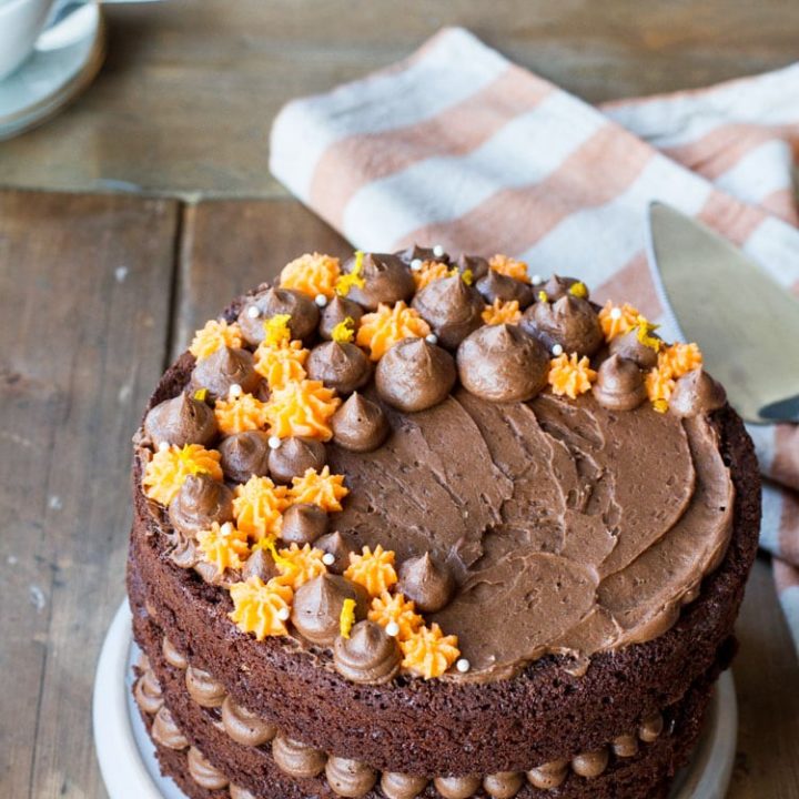 Orange chocolate cake with chocoate and orange colored buttercream on top.