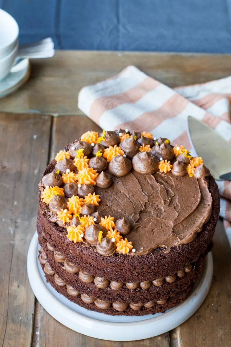 Orange chocolate cake with chocoate and orange colored buttercream on top.