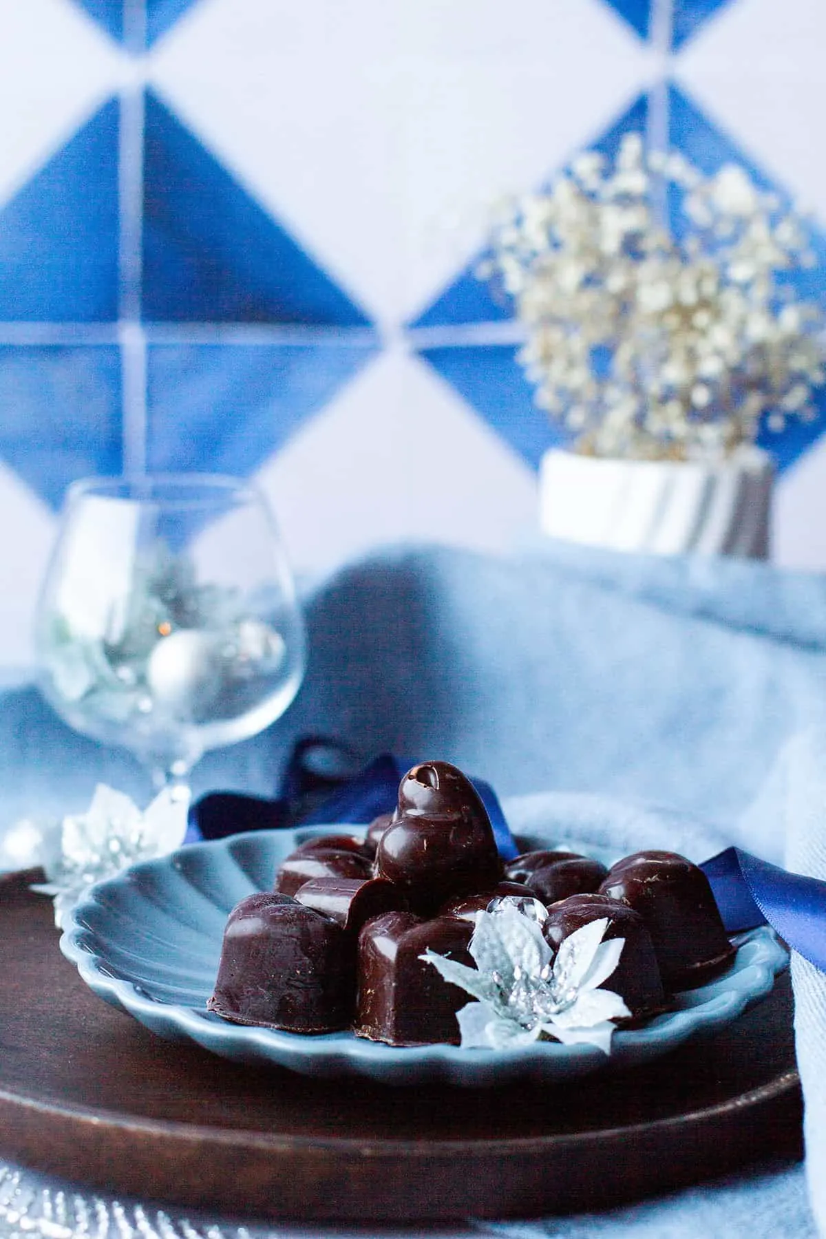 Heart-shaped dark chocolates on a small blue blate.