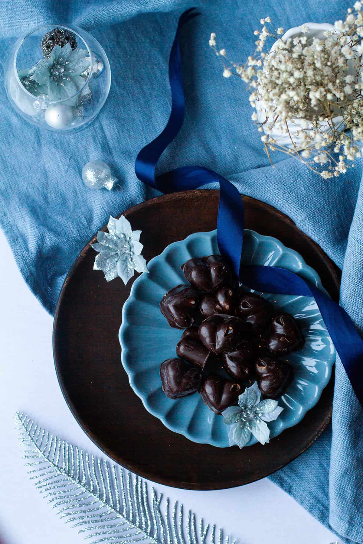 Dark chocolate pieces on a blue plate, seen from above.