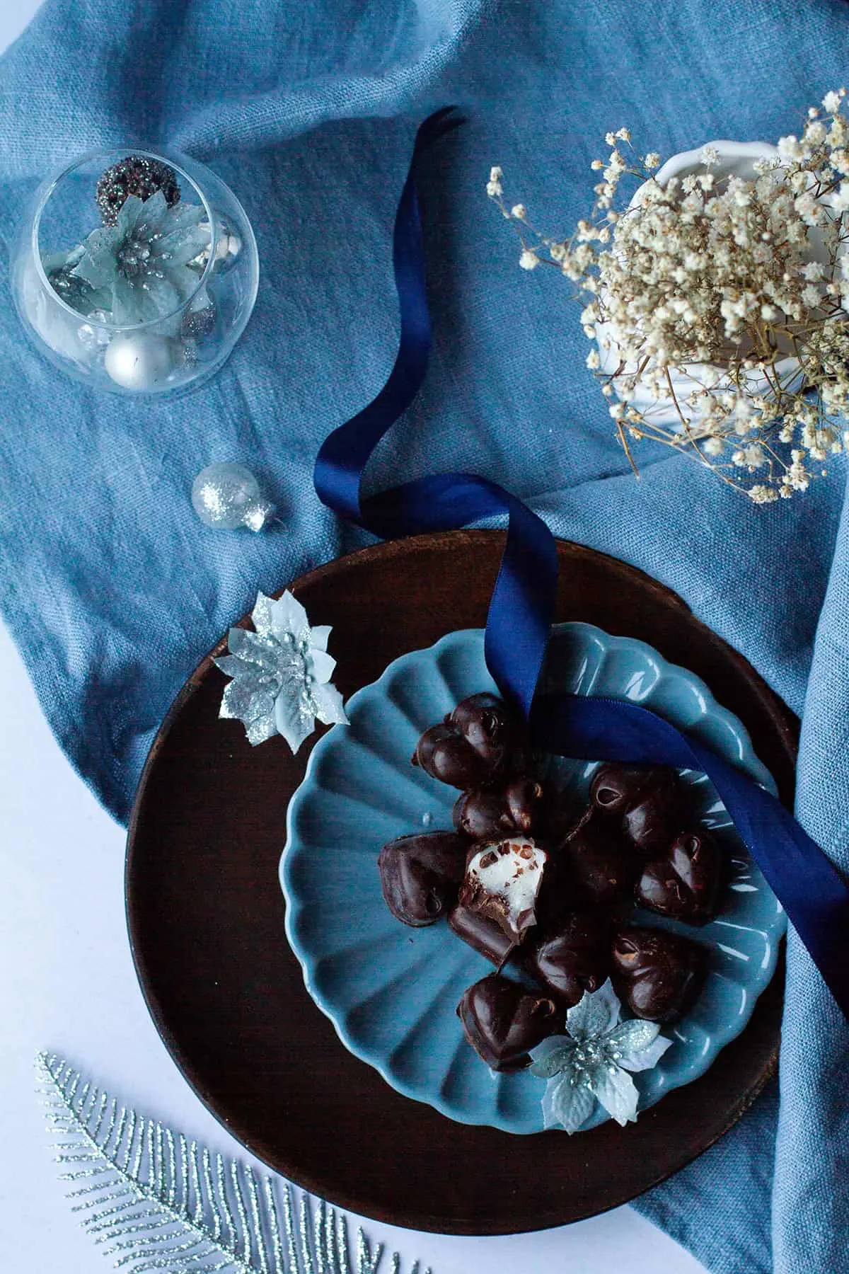 Dark chocolares on a blue plate, one cut open to show the peppermint filling.