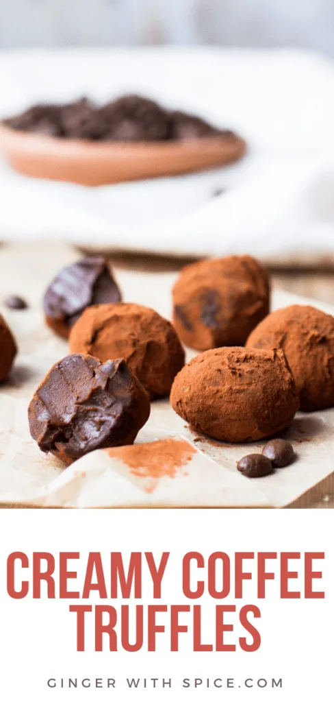 Chocolate Coffee Truffles on brown parchment paper. One is taken a bite of. Covered in cocoa powdered.