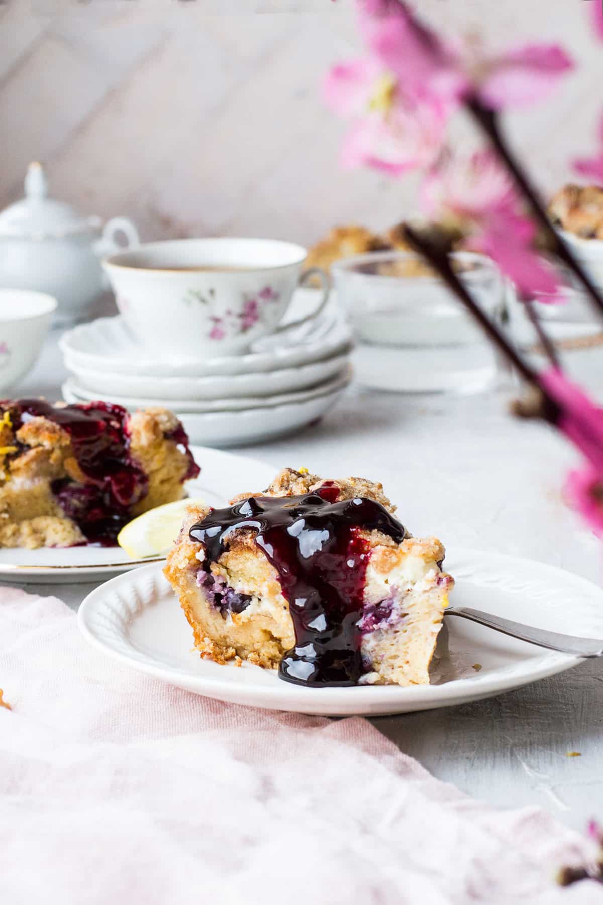 Slice of blueberry French toast on a small plate, topped with blueberry sauce.