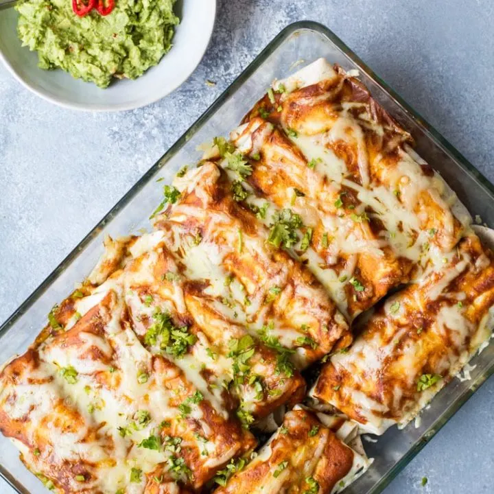 Beef and beans enchiladas in a clear casserole.