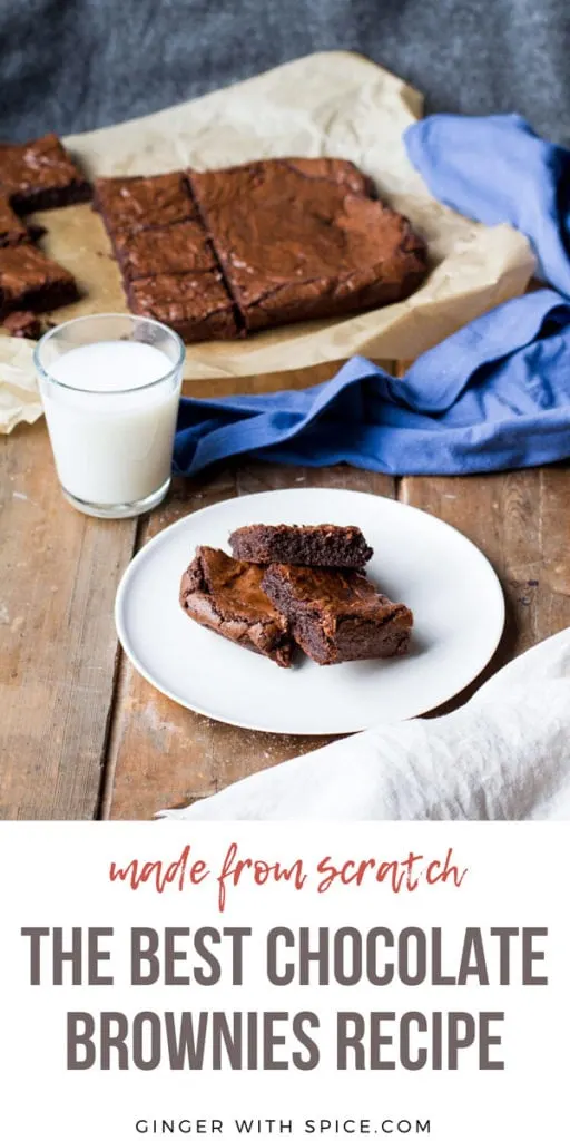 Three brownies on a white plate, blue towel and cake in the background. Pinterest pin.