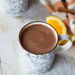Two blue and white patterned mugs with hot orange chocolate.