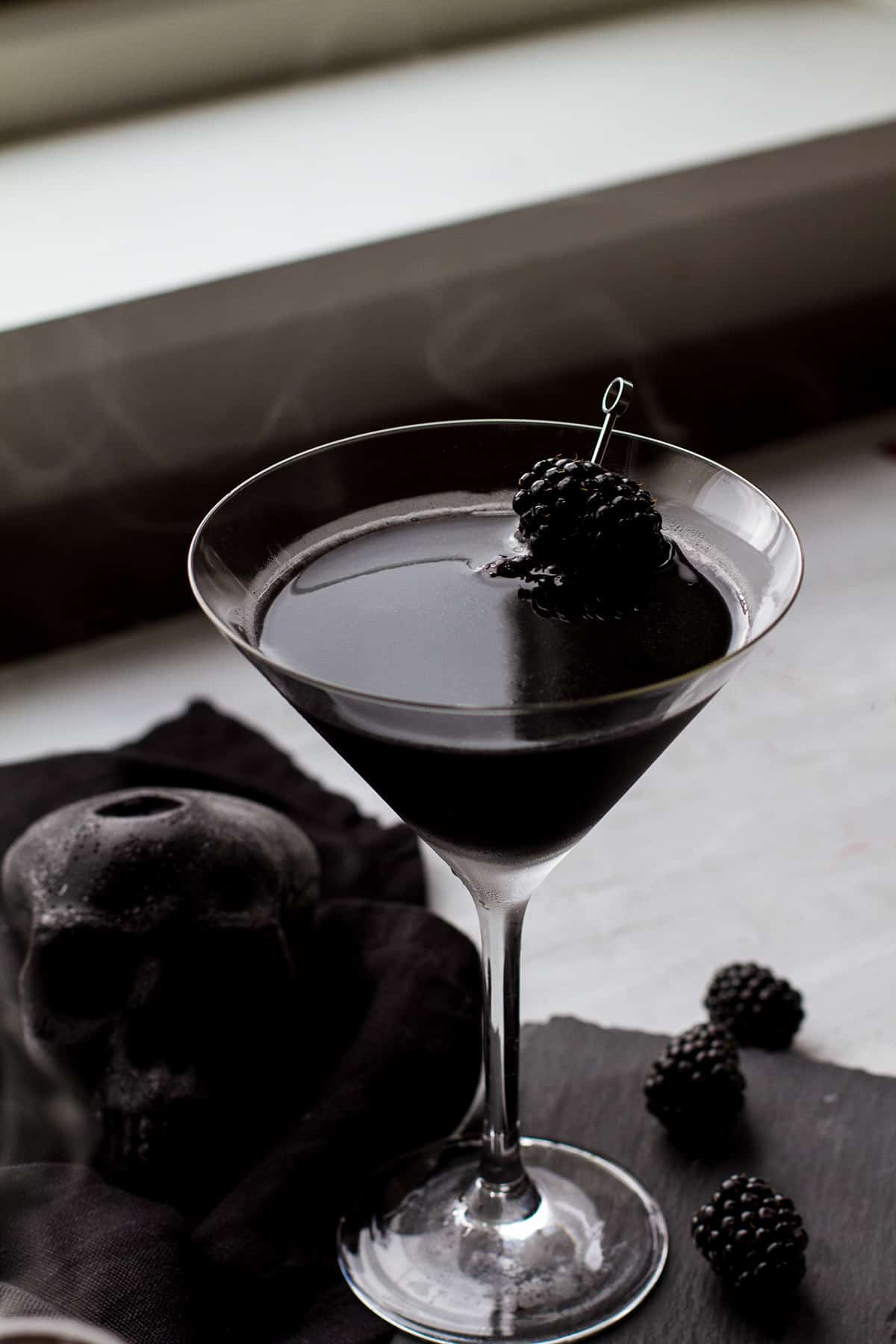 A completely black martini, white background.