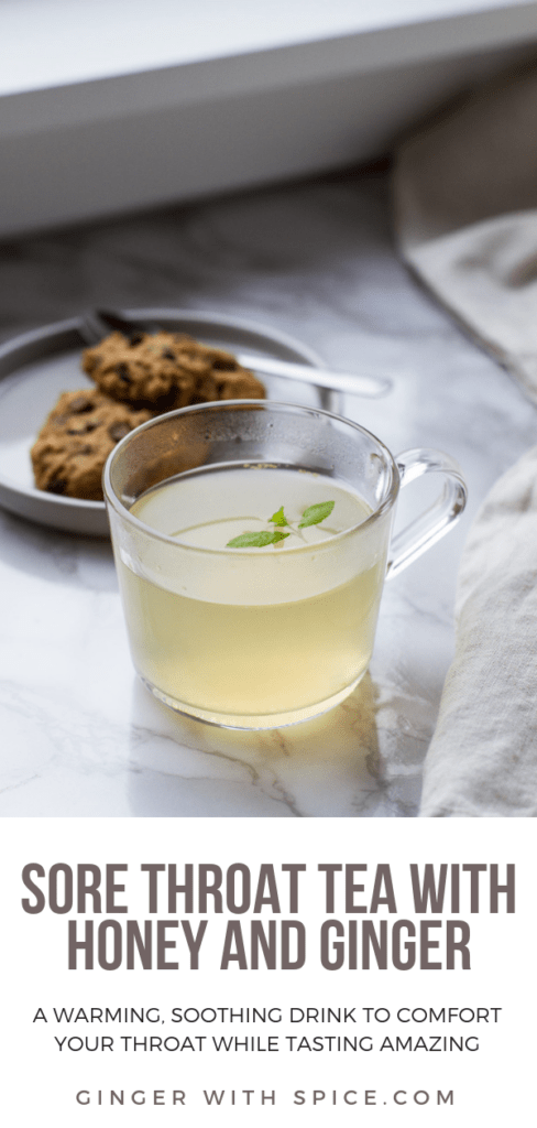 Clear mug with pale yellow drink and lemon verbena garnish. Cookies in the background. Pinterest pin