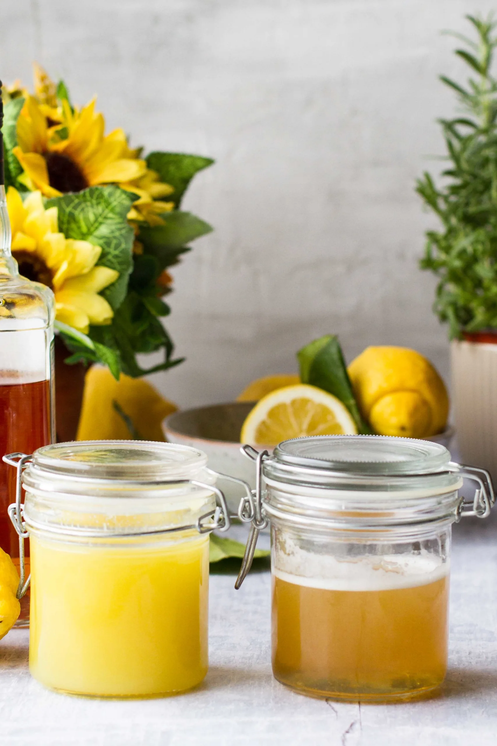 Two glass jars with syrups: one ginger and one honey.