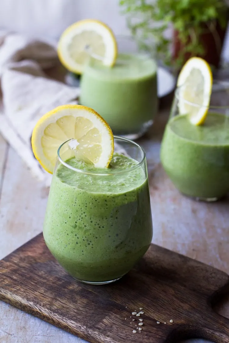 Green smoothie recipe with lemon wedge on glass rim.