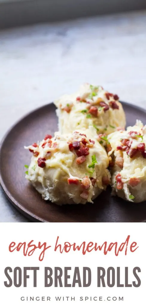 Three homemade dinner rolls with cheese and bacon on a wooden plate. Pin.