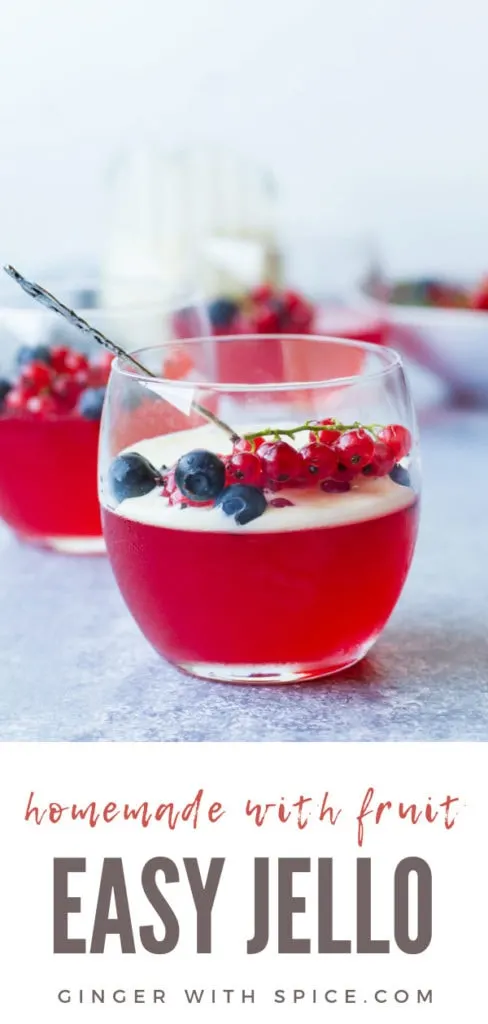 One round glass with homemade jello, vanilla custard sauce and berries. Straight view. Pinterest pin.