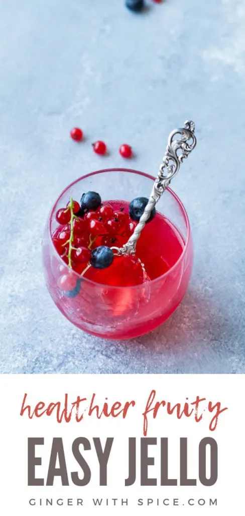 One glass with homemade jello recipe, berries and a vintage spoon. Pinterest pin.
