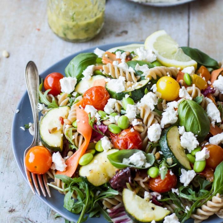 Healthy pasta salad with crumbled feta cheese, roasted tomatoes and zucchini.