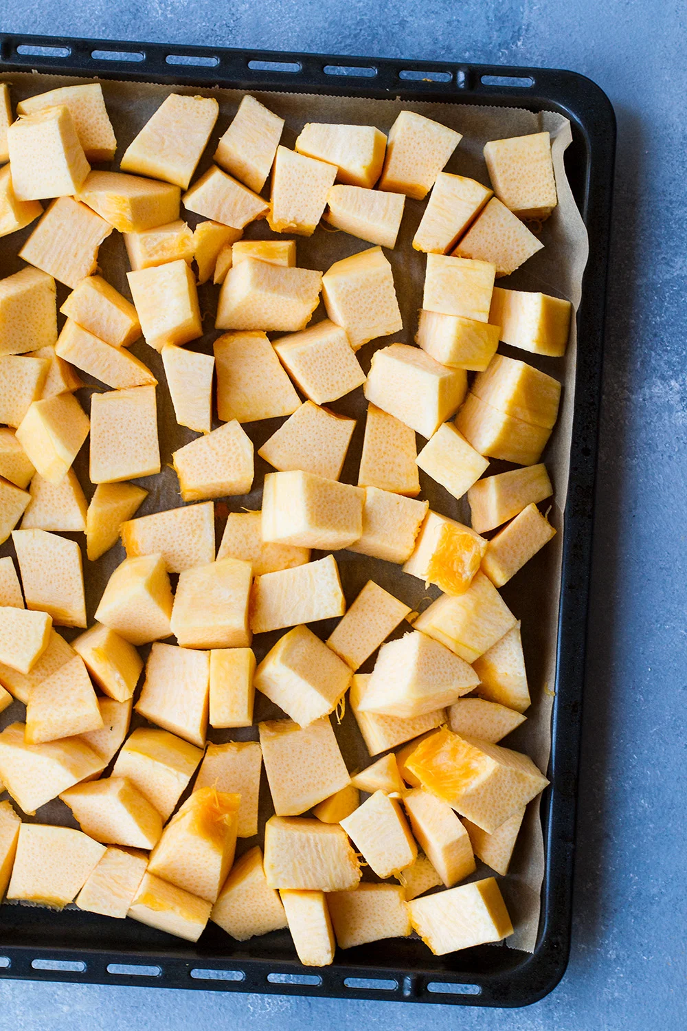 A sheet pan with cubed butternut squash.