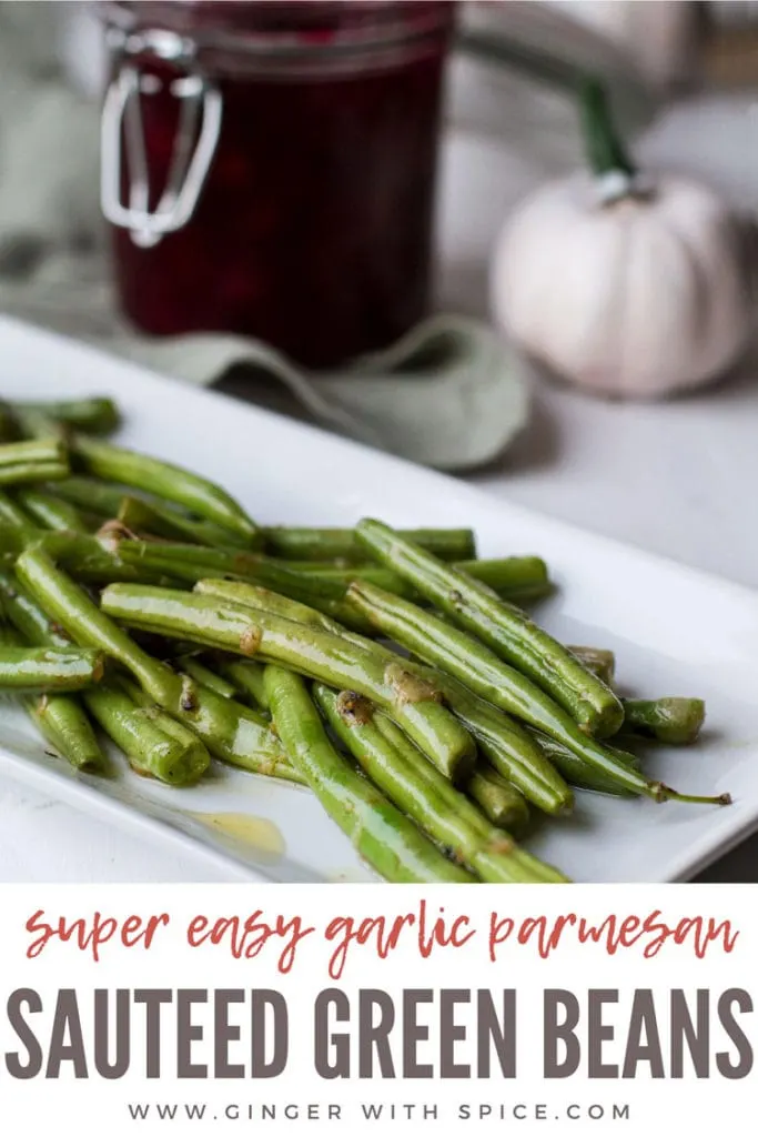 Garlic Parmesan Green Beans on a white, rectangular plate. Cranberry sauce in the background. Pinterest pin.