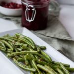 Sauteed green beans on a white, rectangular plate.