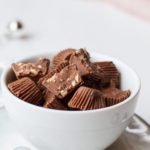 Almond Crunch Milk Chocolates, a few cut open, in a small white cup.