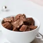 Almond Crunch Milk Chocolates, a few cut open, in a small white cup.