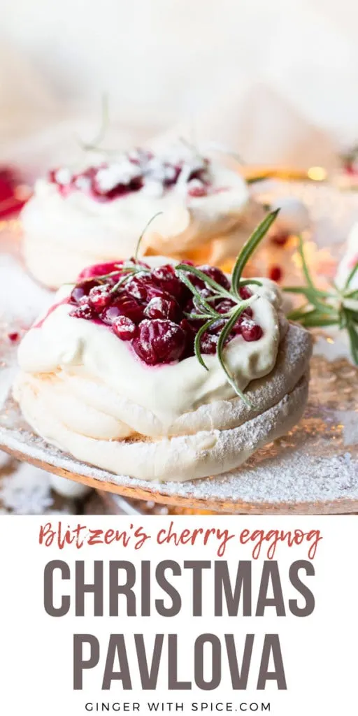 Christmas Pavlova Dessert with cherry sauce and rosemary sprig on a cake stand. Pinterest pin.