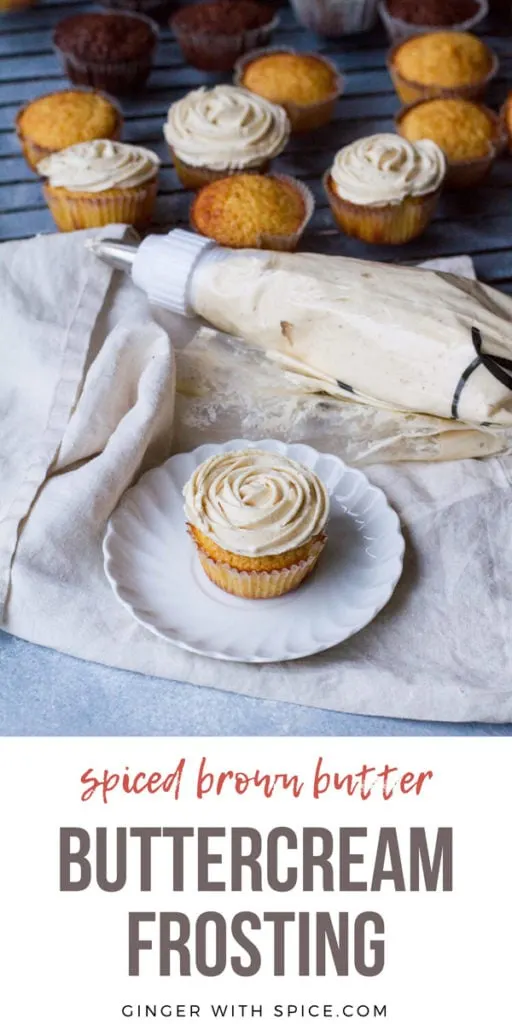 A cupcake with flower buttercream frosting on a white plate, a piping bag and muffins in the background. Pinterest pin.