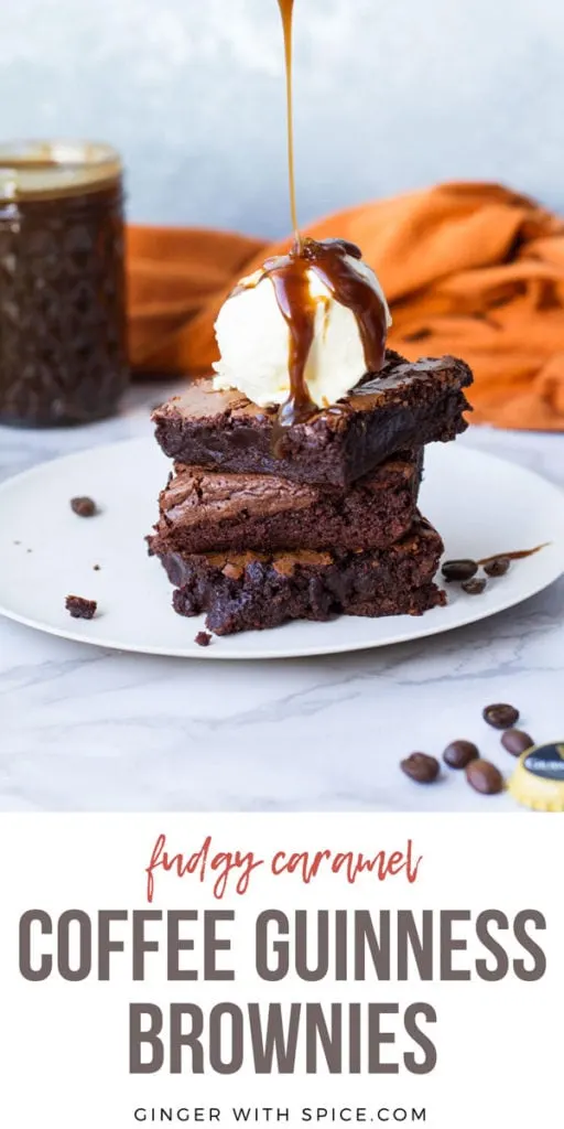 Three Guinness caramel brownie squares stacked on a white plate, ice cream scoop and caramel on top. Pinterest pin.