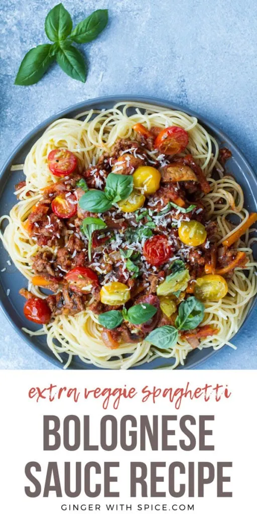 Spaghetti bolognese on a grey plate, blue background. Pinterest pin.