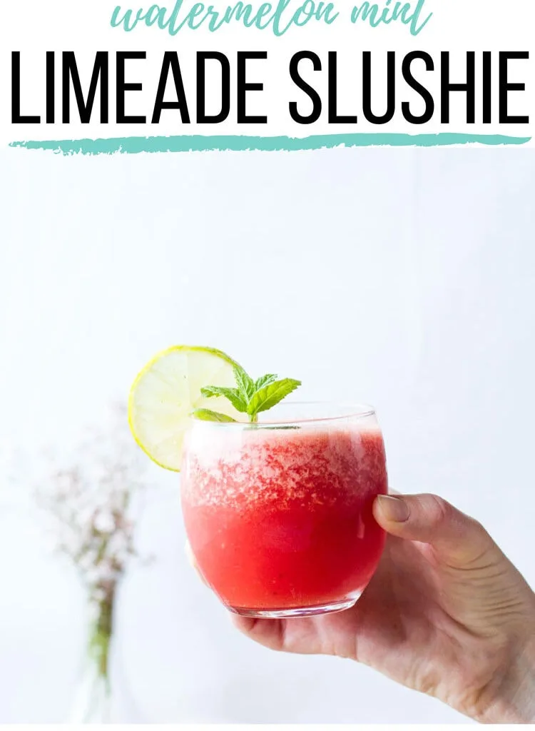 Hand holding a glass of watermelon limeade, garnised with lime and mint. Pinterest pin.