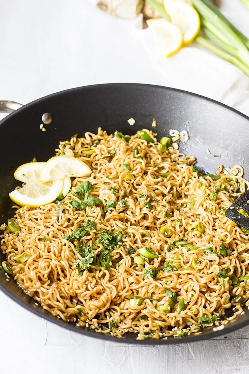 Skillet with fried noodles and green onion.