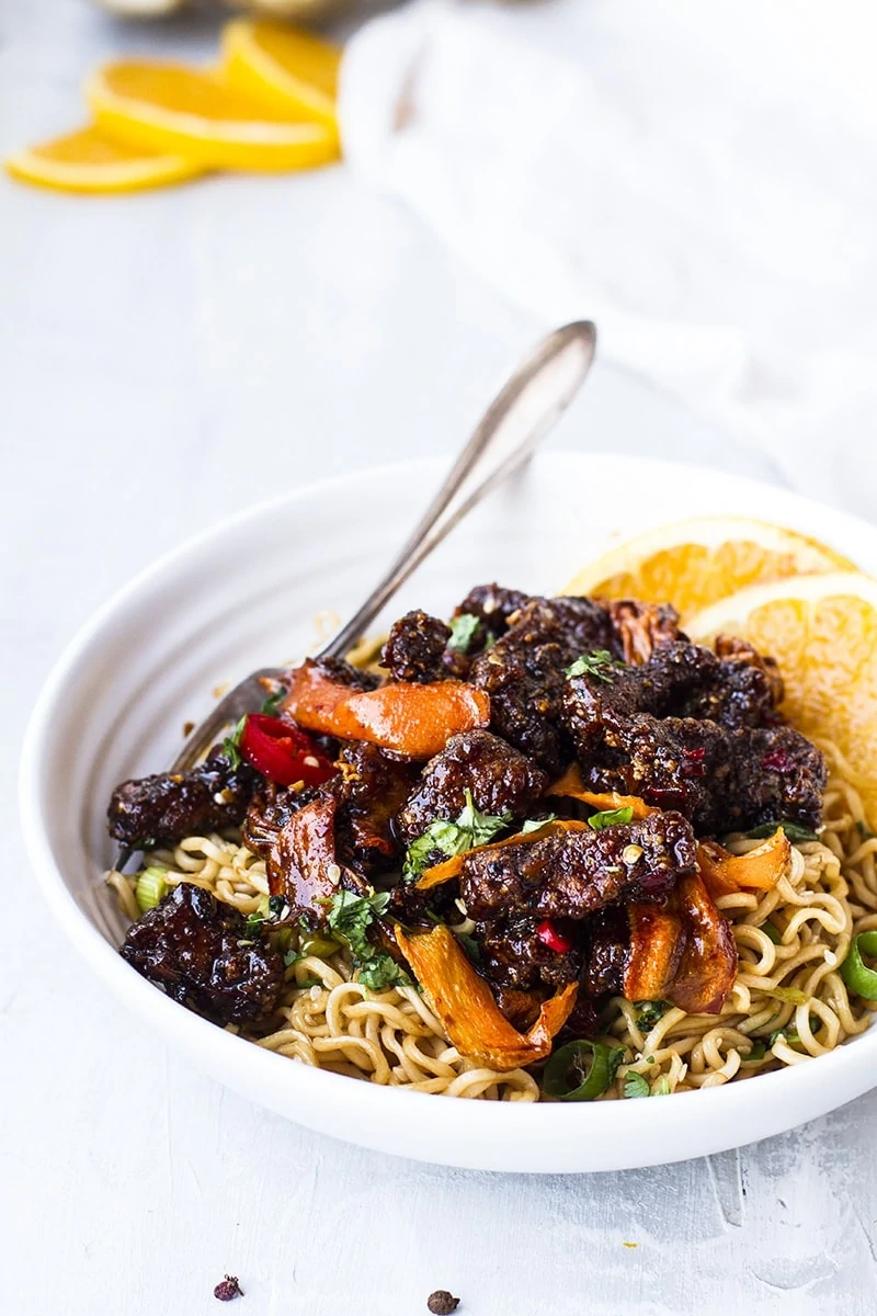 Szechuan beef and carrots over a bed of noodles.