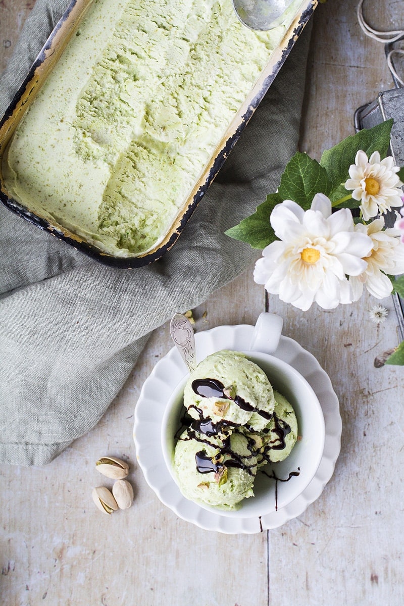 Pistachio ice cream in a bread pan and a serving in a cup.