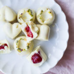 Close-up of the white chocolates, some open to show the filling. Flatlay.