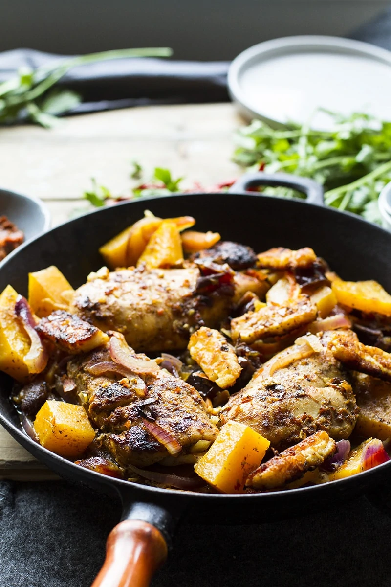 Charred chicken breast and butternut squash in a cast iron skillet.
