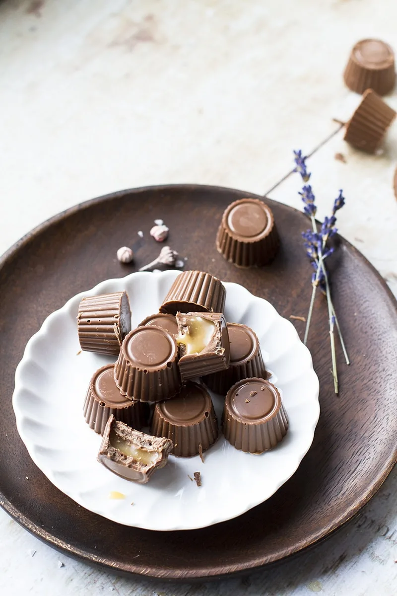 Vintage white plate with milk chocolates and caramels, dried lavender as decor.