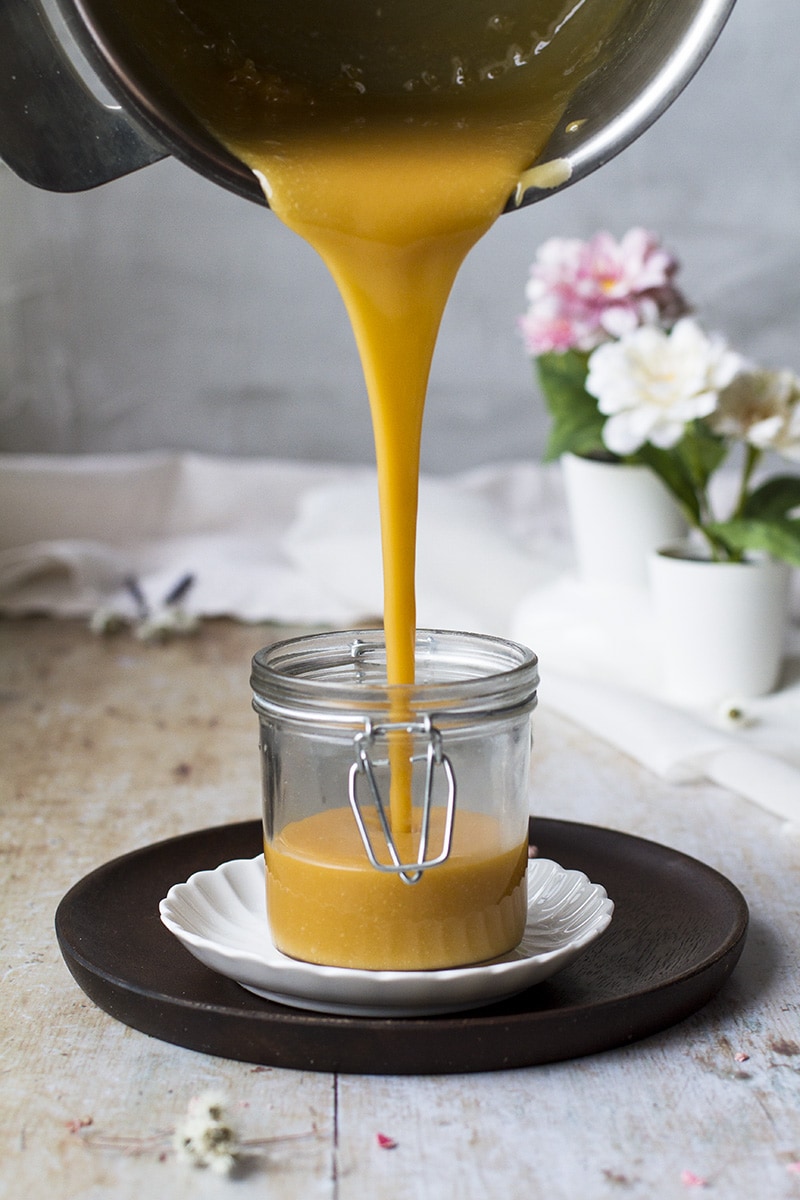 Pouring salted caramel into glass jar.