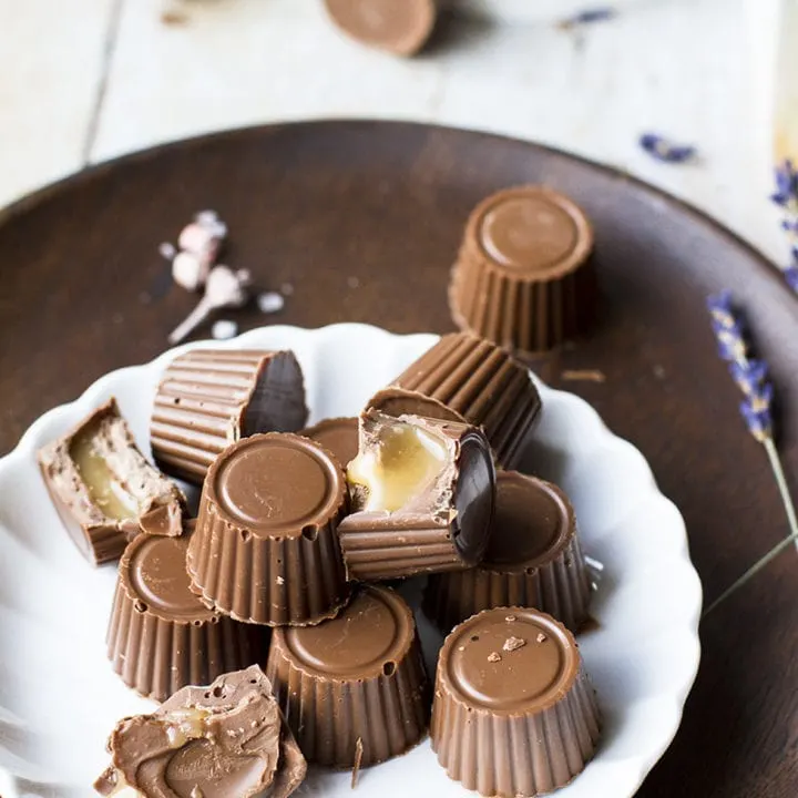 White plate with milk chocolates, some open showing the caramel inside.
