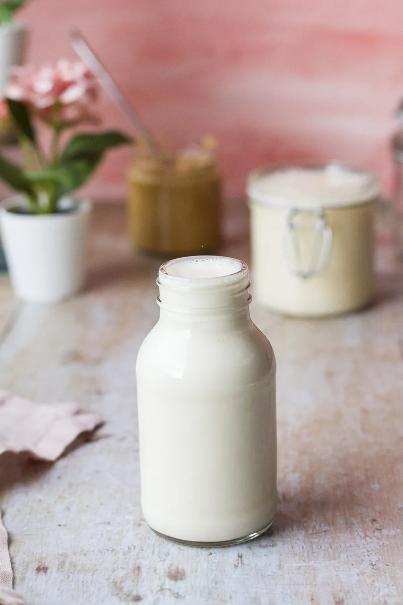 A small glass bottle filled to the brim with evaporated milk.