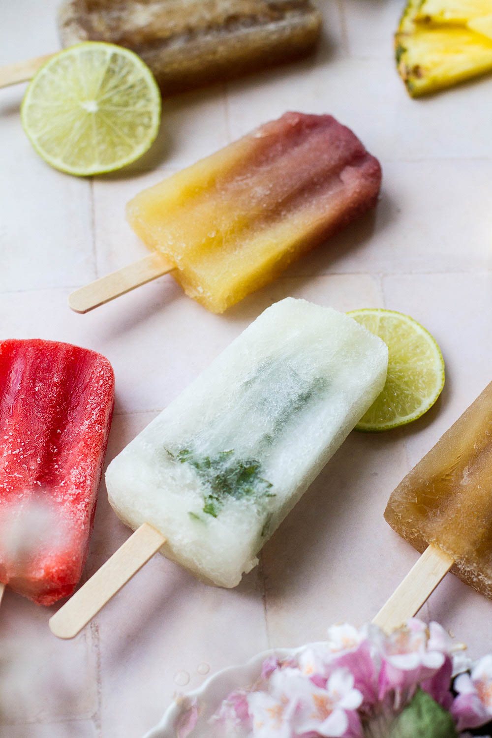 Several popsicles laying on the counter but focus on mojito popsicle.