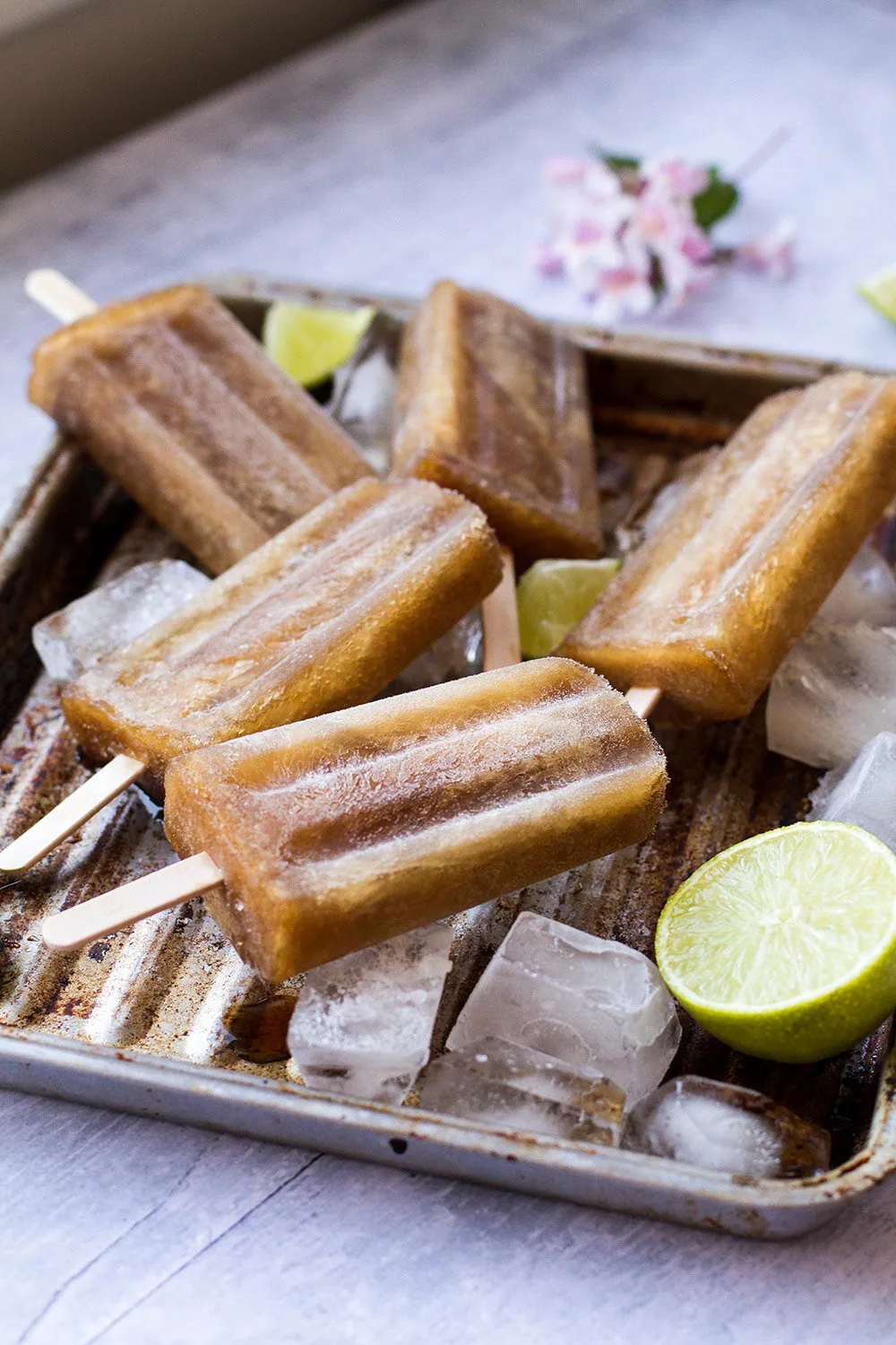 A metal tray with ice cubes, limes and Cuba Libre popsicles.
