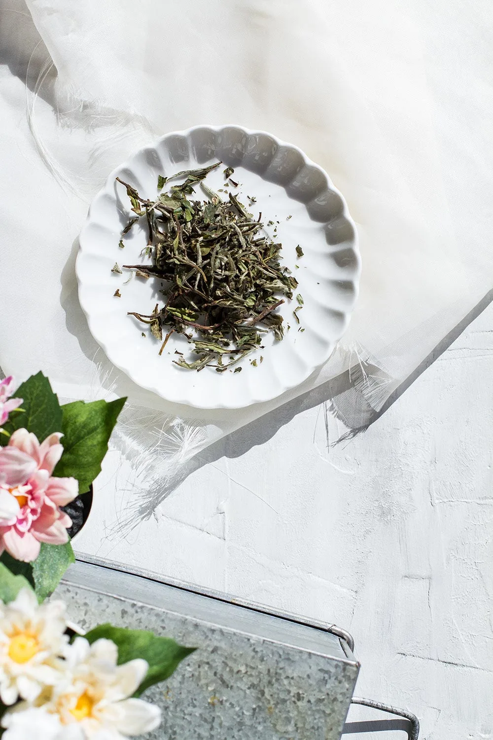 A vintage plate with white tea leaves.