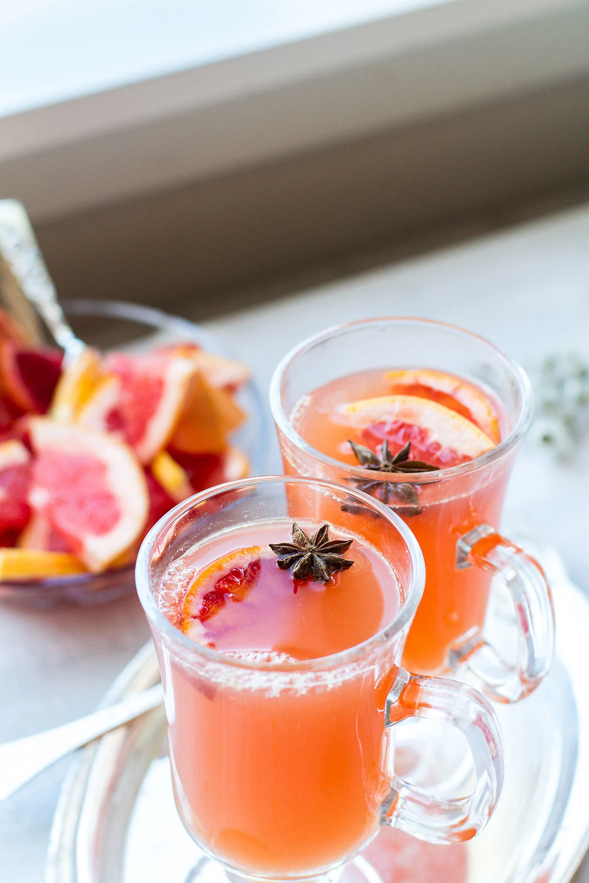Two glass mugs with calendula tea and grapefruit cider.