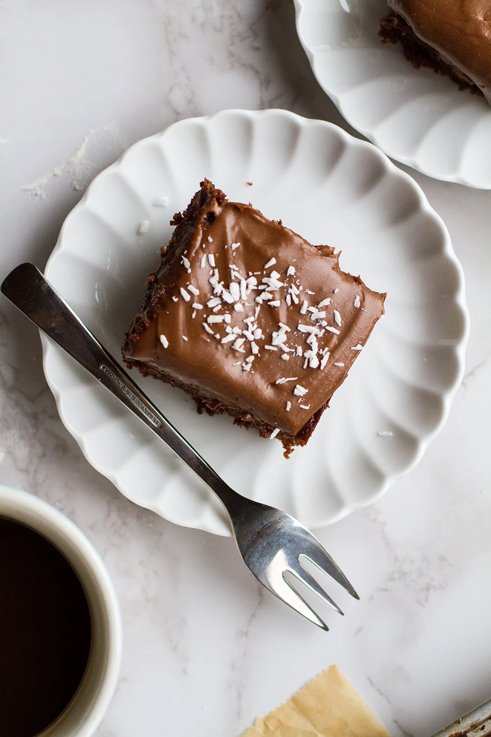 Slice of chocolate cake with shredded coconut as topping.