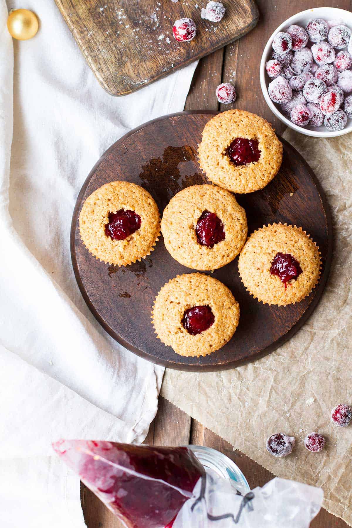 Muffins seen from above, cut hollows filled with cranberry sauce.
