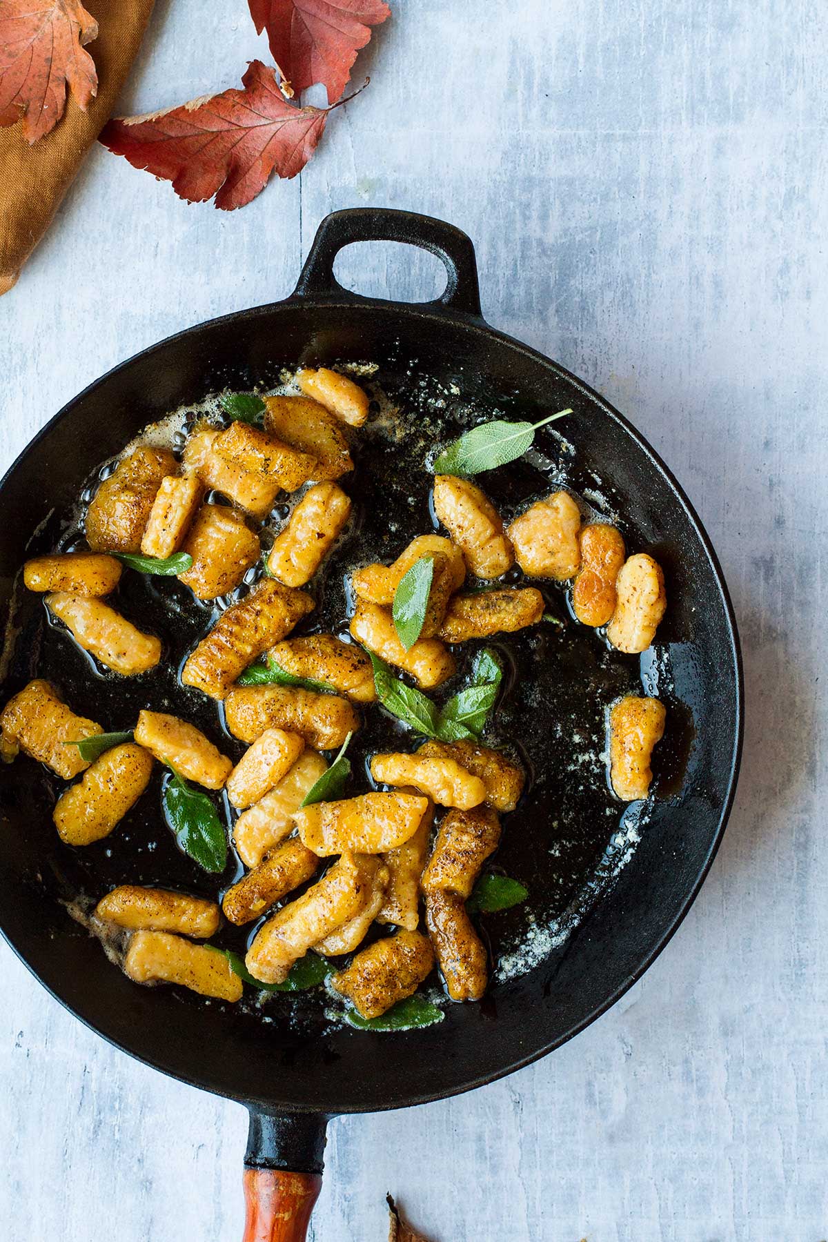 Cast iron skillet with pumpkin gnocchi and sage.