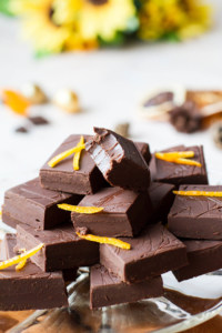 A stack of chocolate fudge, one is taken a bite of.